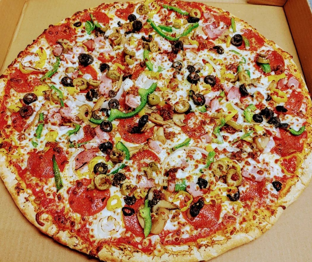 Fully loaded pizza with ham and olives